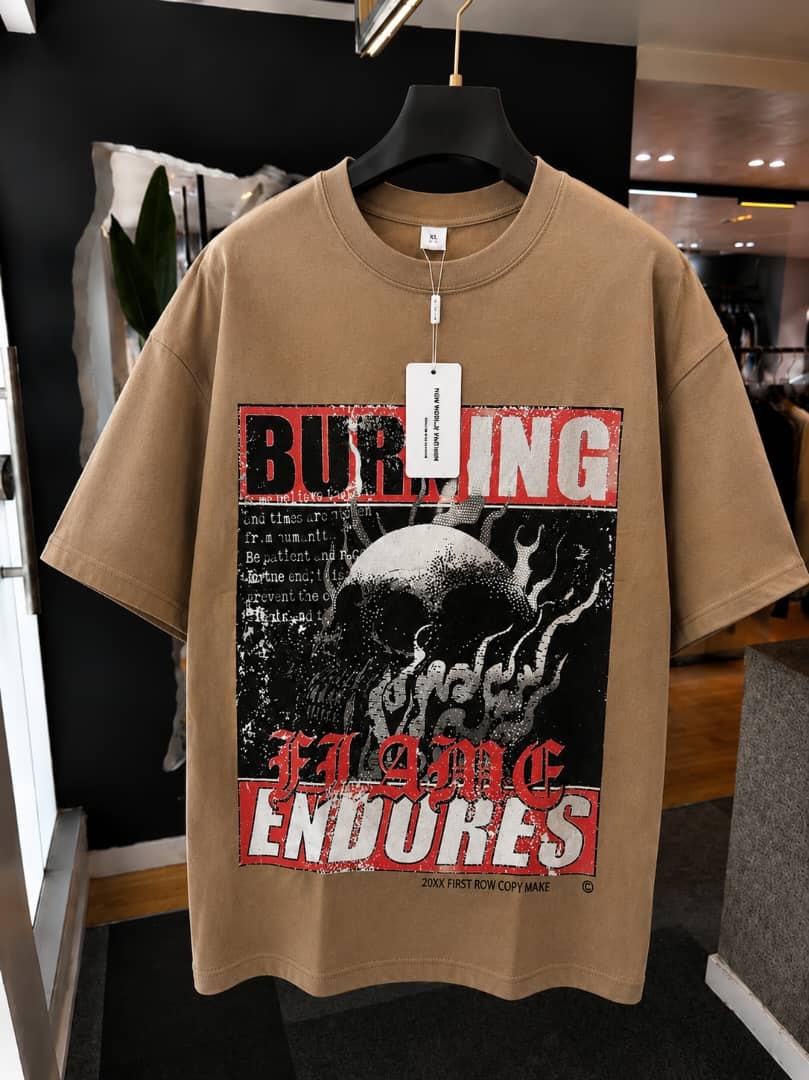 Beige oversized t-shirt with burning flame endures skull graphic print.
