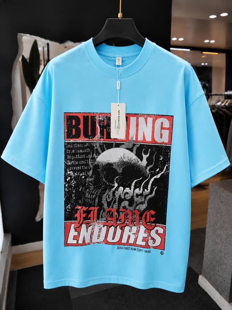 Light blue oversized t-shirt with burning flame endures skull graphic print.