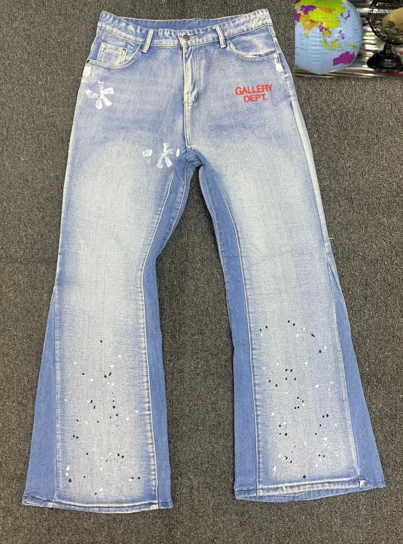 Light blue flared jeans with Gallery Dept text, paint splatters and dots in flat lay.