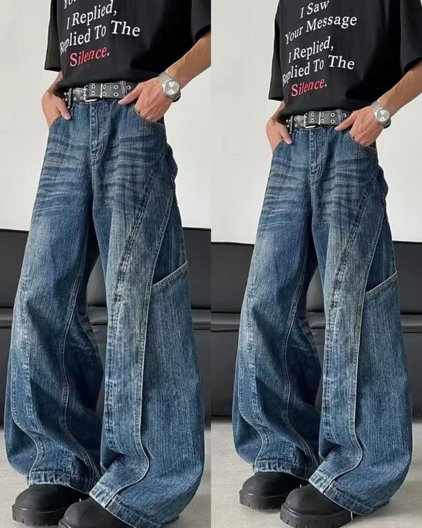 Model in black graphic t-shirt and blue wide-leg jeans with panel details and belt, shown in two poses with hands in pockets.
