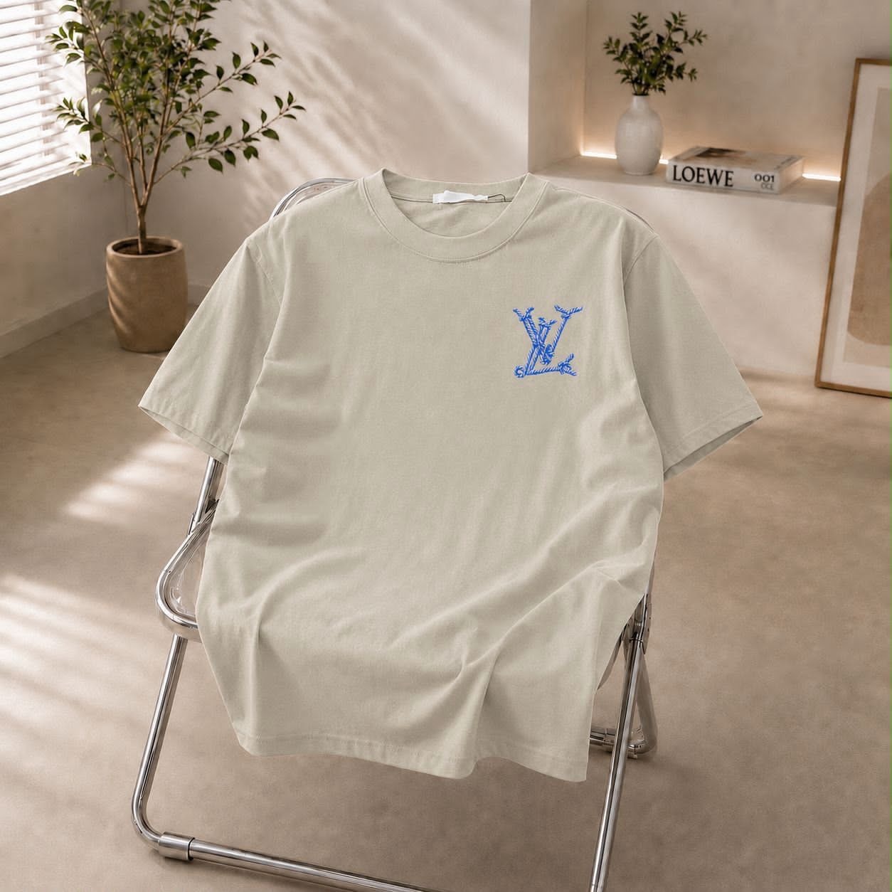 Cream t-shirt with blue LV embroidered logo on chest.