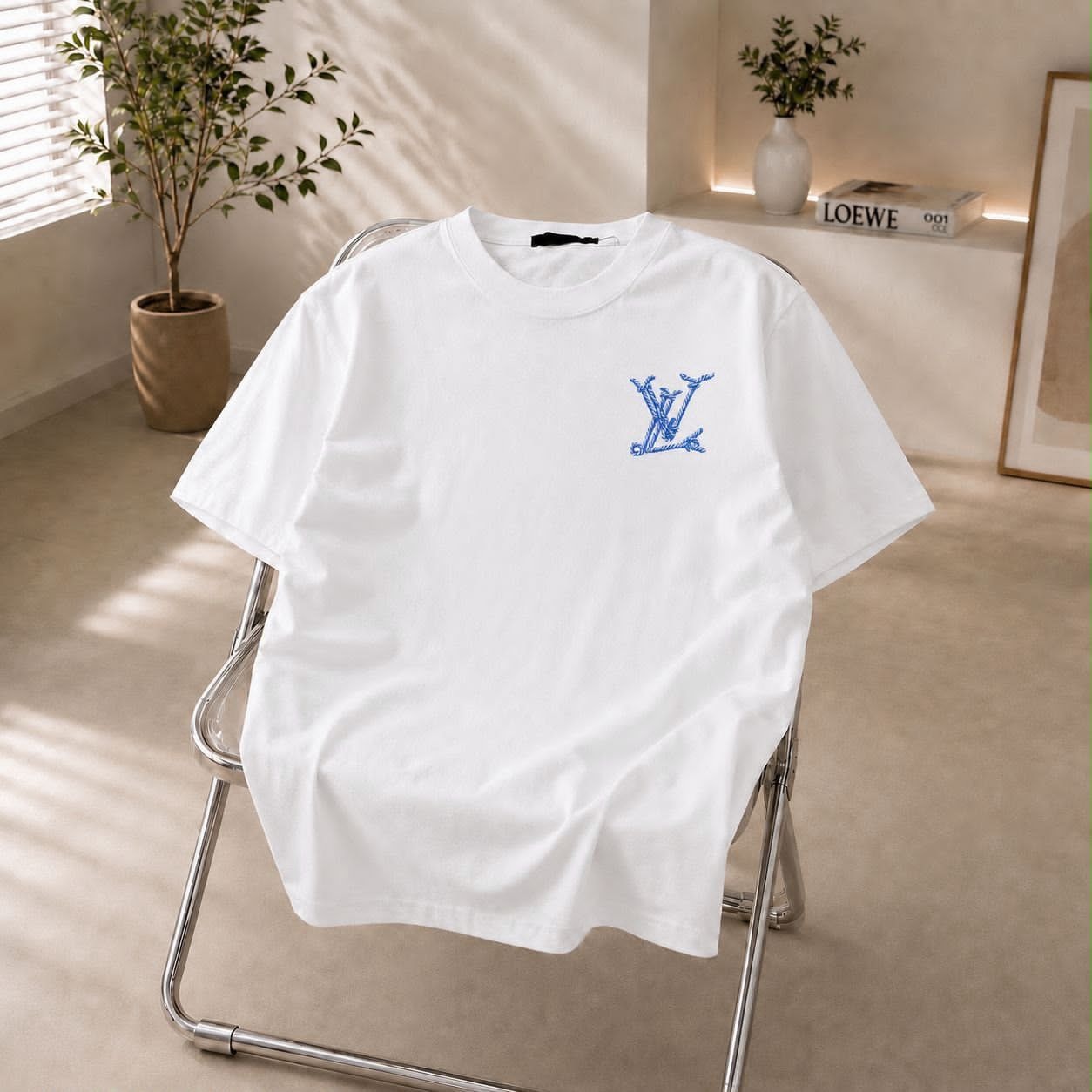 White t-shirt with blue LV embroidered logo on chest.