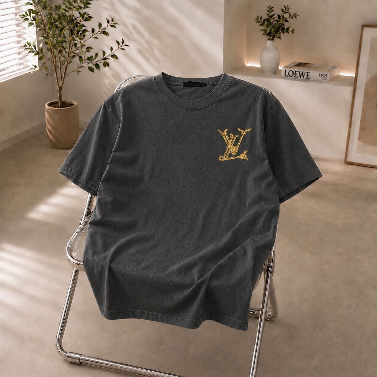 Dark gray t-shirt with gold LV embroidered logo on chest.