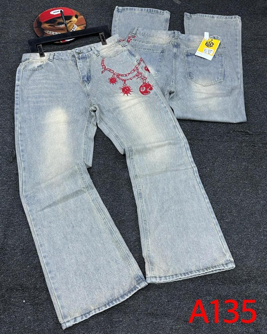Light blue baggy jeans with red embroidery on back pocket and chain, shown with folded view.