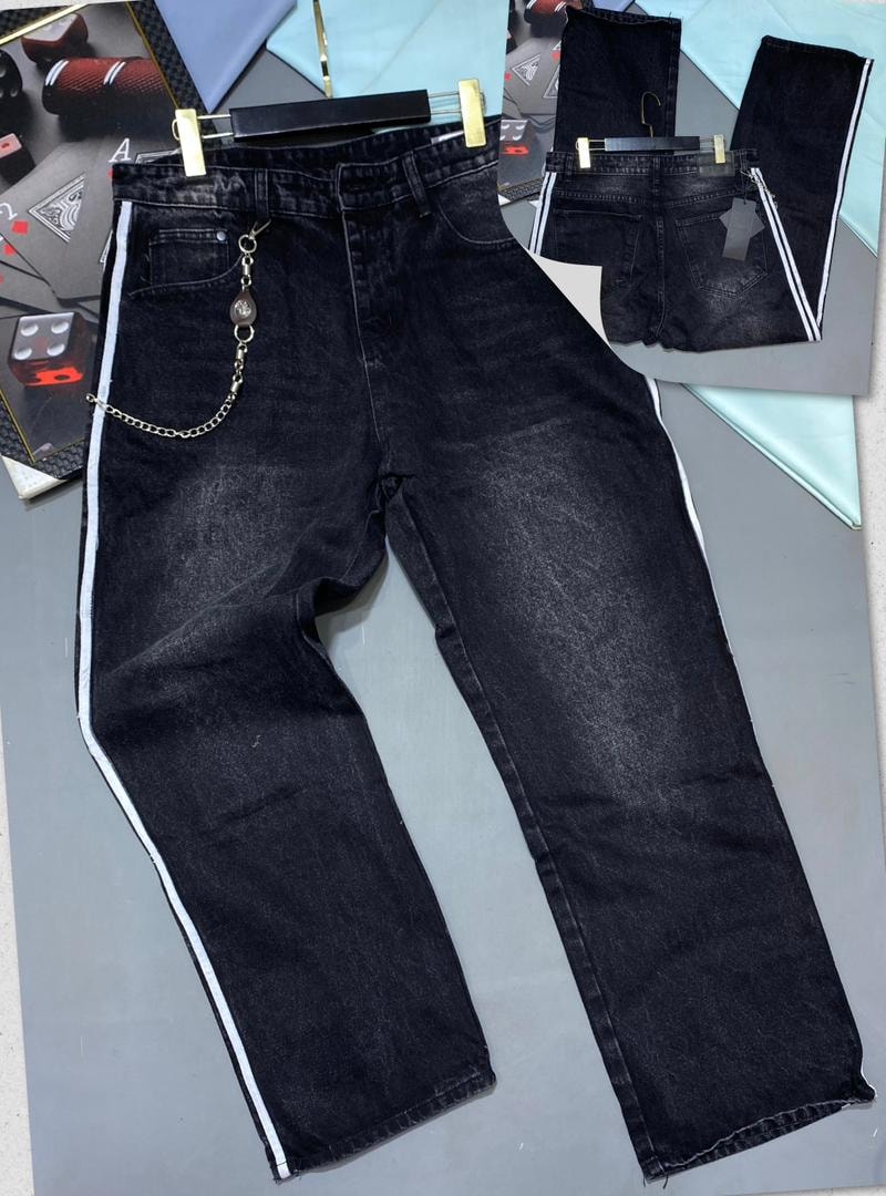 Front and back views of black baggy jeans with white side stripes and decorative chain.