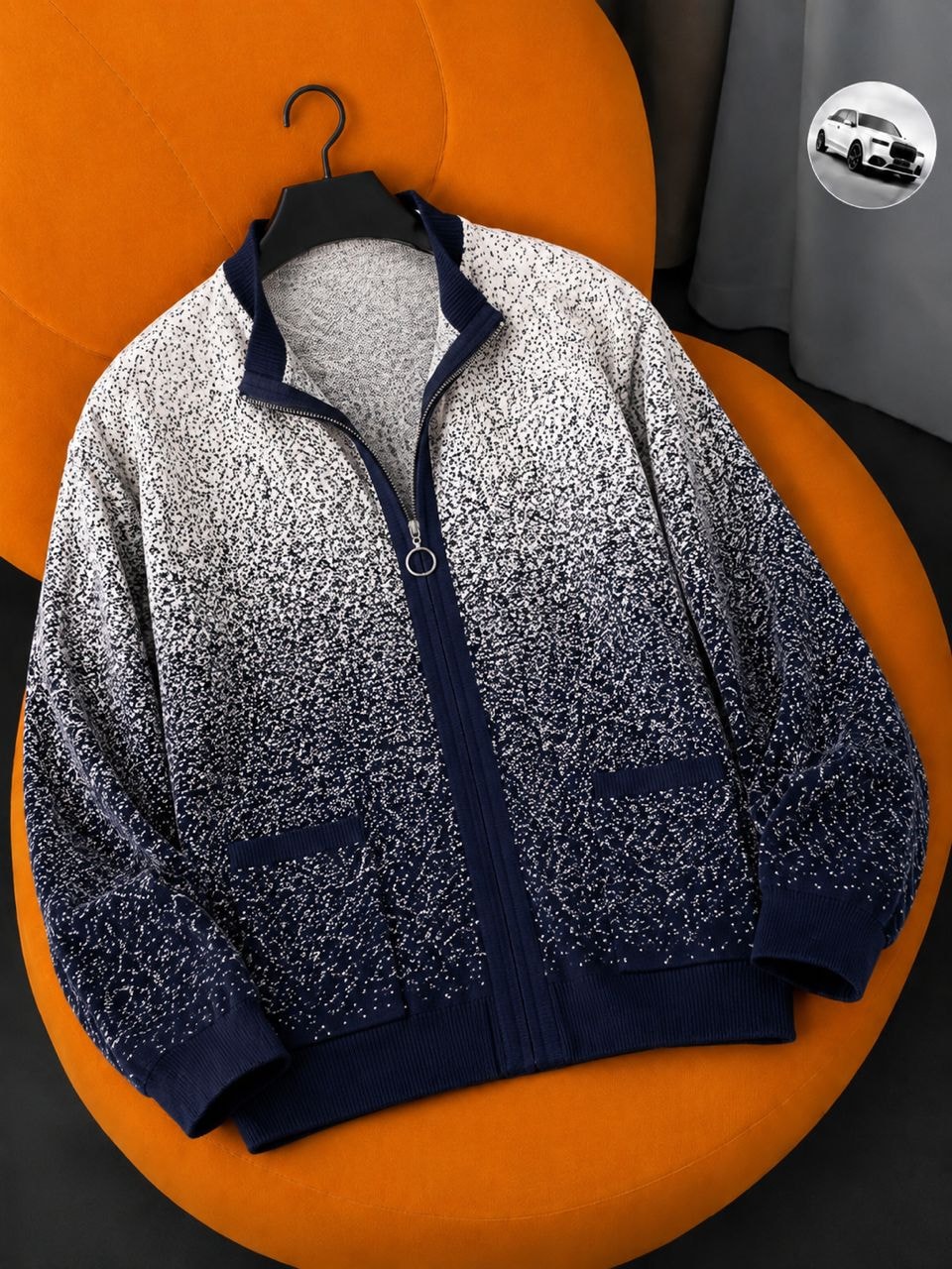 Speckled navy and white zip-up jacket on orange chair with car inset.
