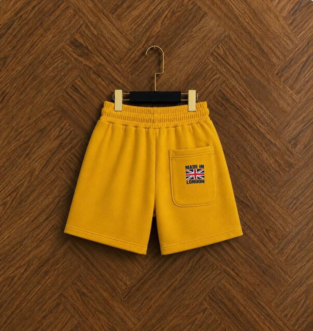 Yellow unisex fleece shorts back view showing embroidered patch pocket.