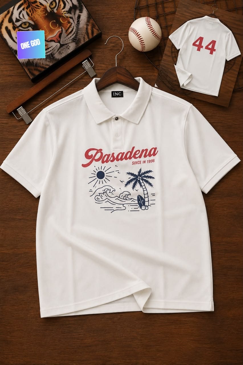 White polo shirt with red Pasadena graphic print, palm tree and wave design on wooden surface.