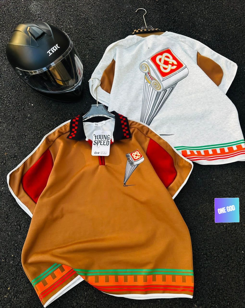 Brown polo shirt with column graphic on chest beside white version displaying large back graphic, both with striped hems.