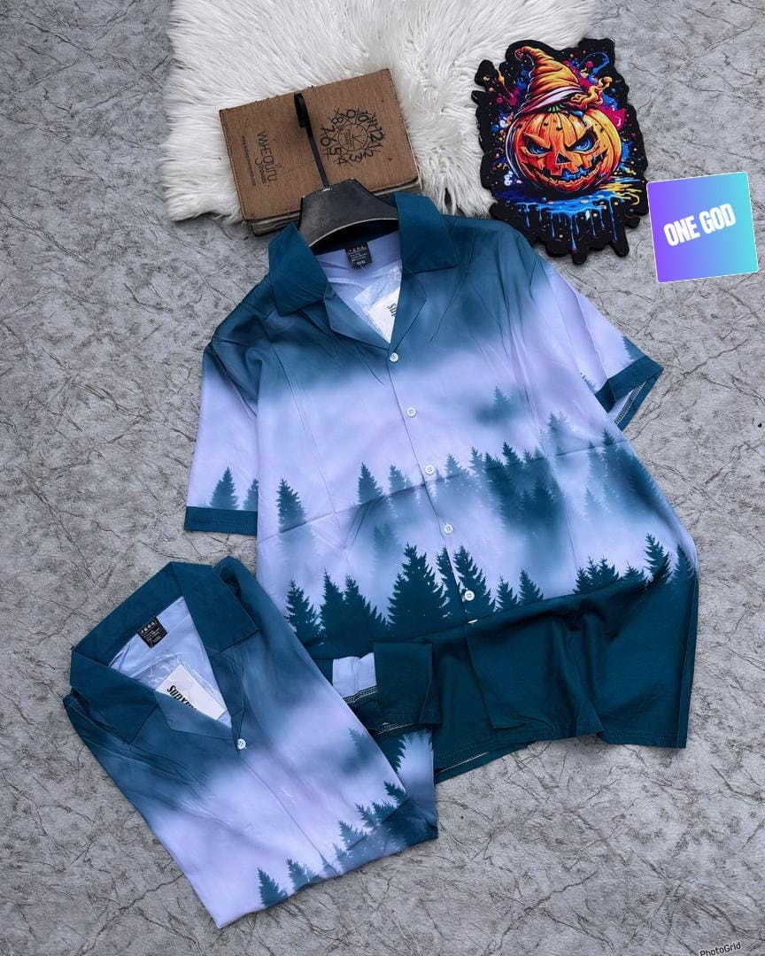 Teal blue gradient short sleeve shirt with dark green forest tree silhouettes.