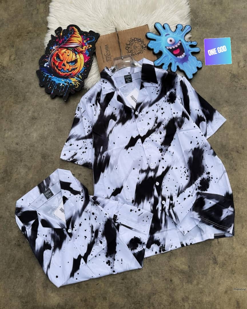 Short sleeve shirt with black ink splatter pattern on white background.