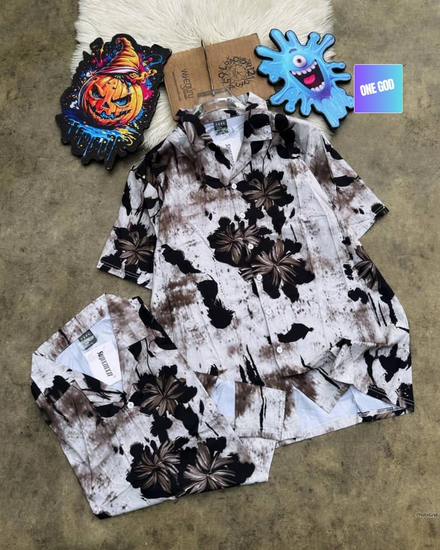 Short sleeve shirt with brown and black floral tie-dye pattern on white, shown hanging and folded.