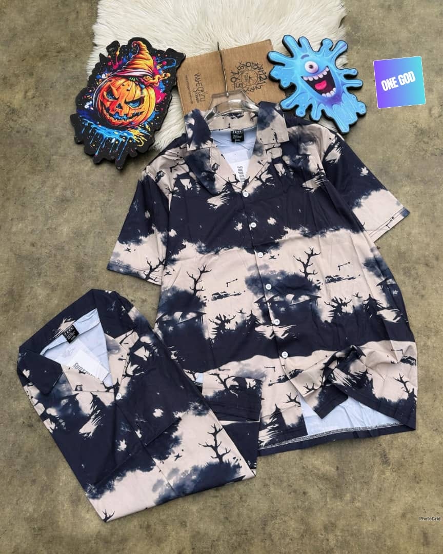 Beige black tie-dye short sleeve shirt with tree and bird prints, displayed hanging and folded.