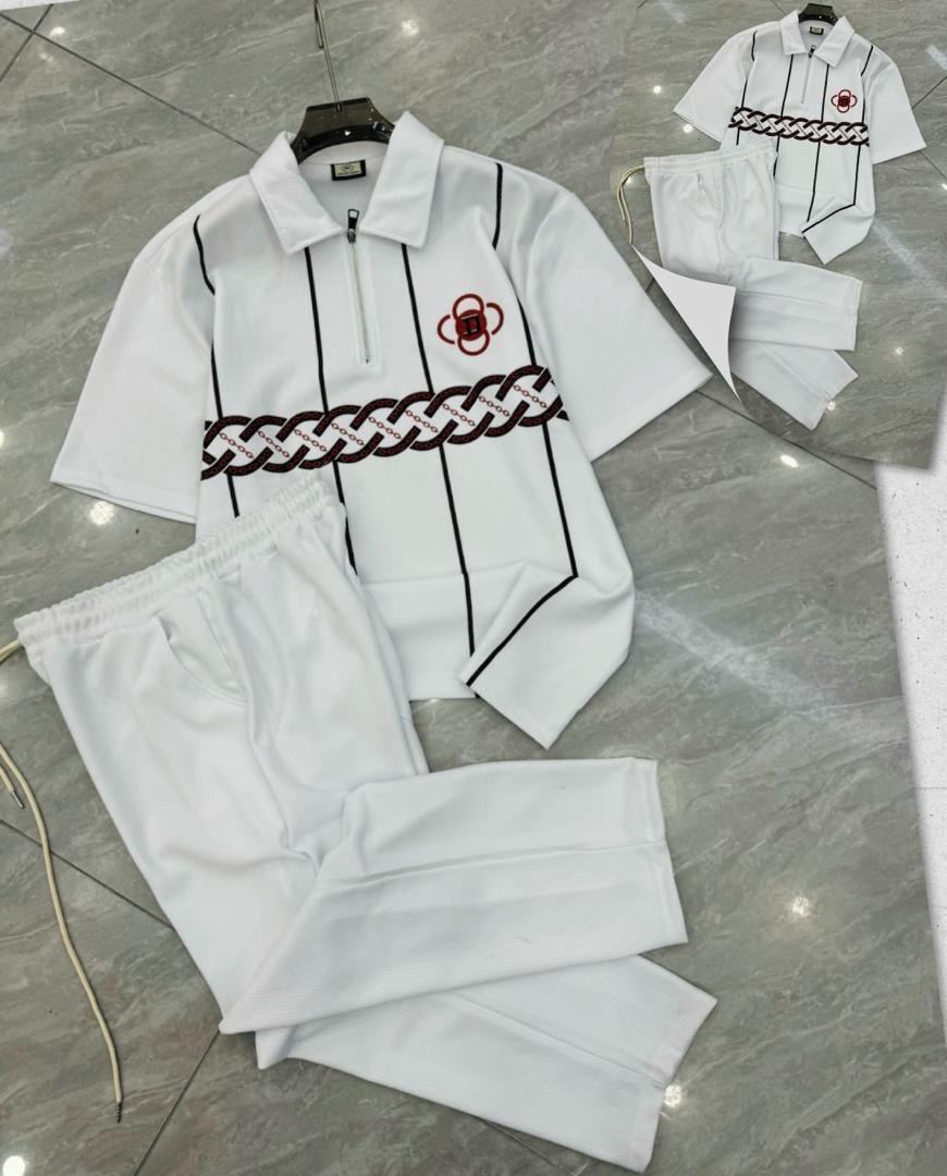 White polo shirt with black stripes, chain print and red emblem, paired with white pants.