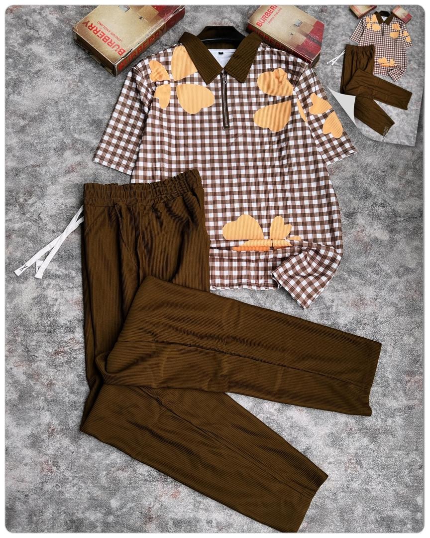 Brown and white gingham polo with orange hearts and brown pants.