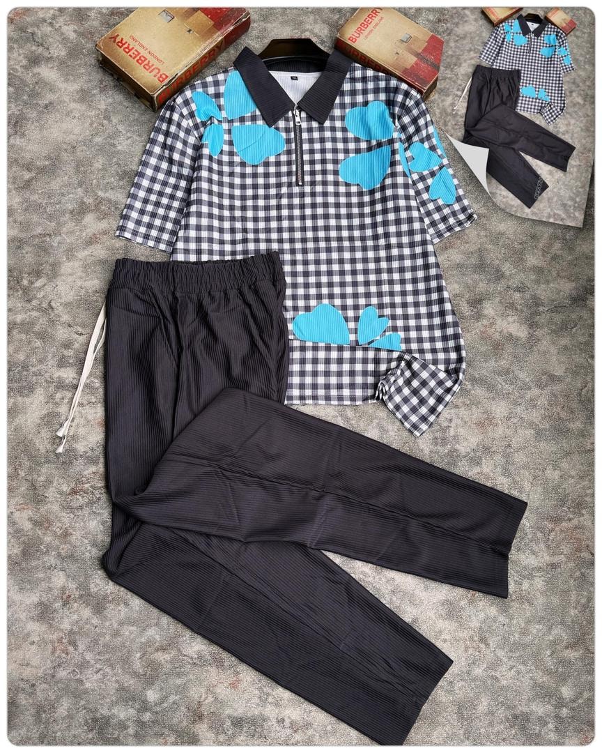 Black and white gingham polo with blue hearts paired with black pants.