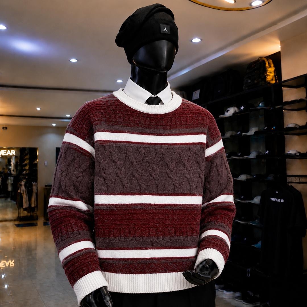 Mannequin in burgundy striped knit sweatshirt with white bands and cable knit patterns.