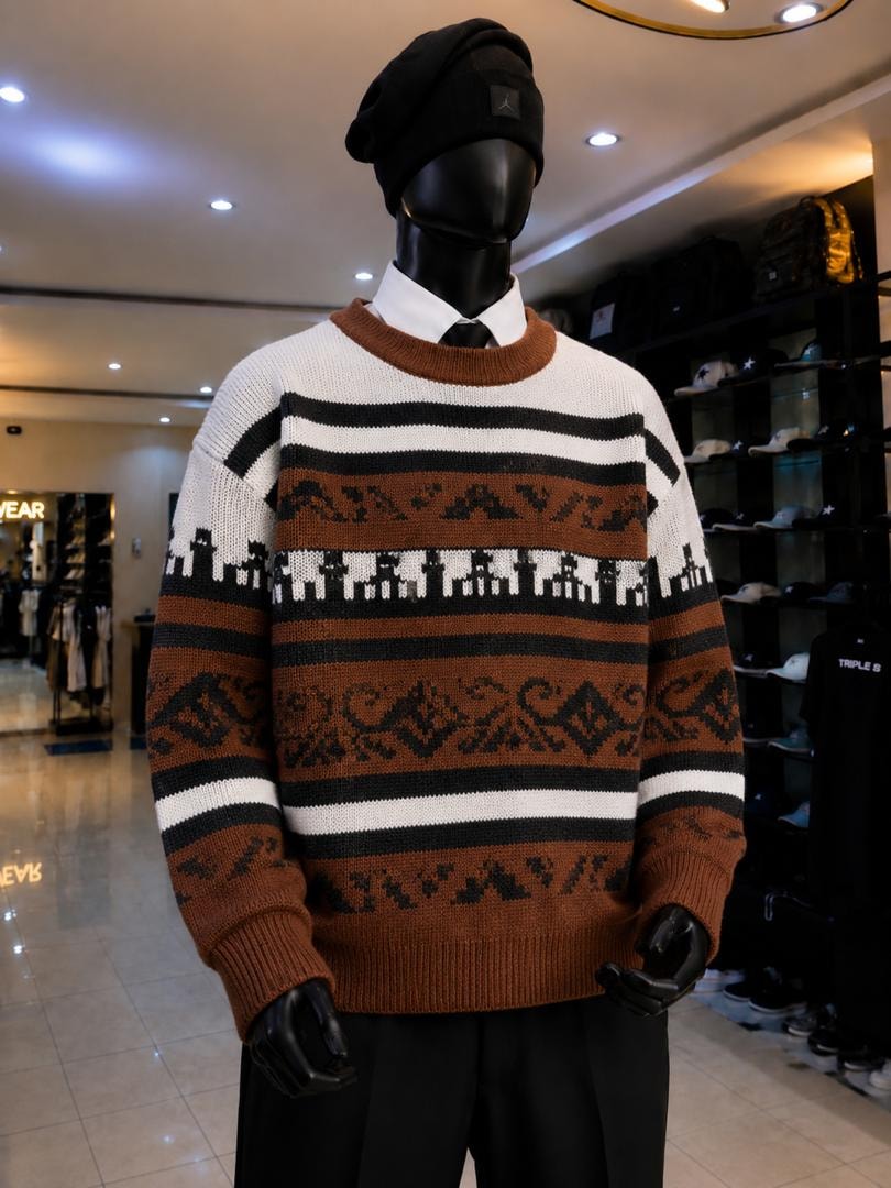Mannequin wearing brown striped knit sweatshirt with black and white geometric patterns including city motifs.