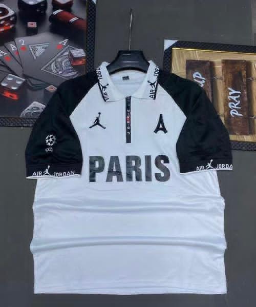 White and black PSG Jordan Paris football jersey on hanger with background props.