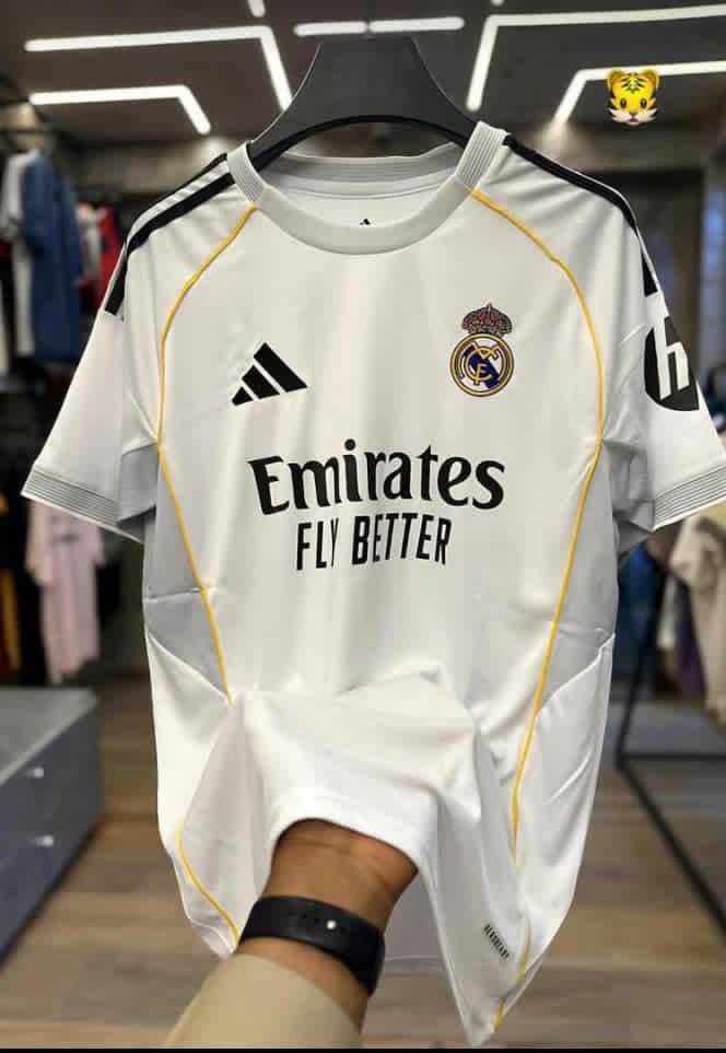 White Real Madrid adidas jersey held up in retail store.
