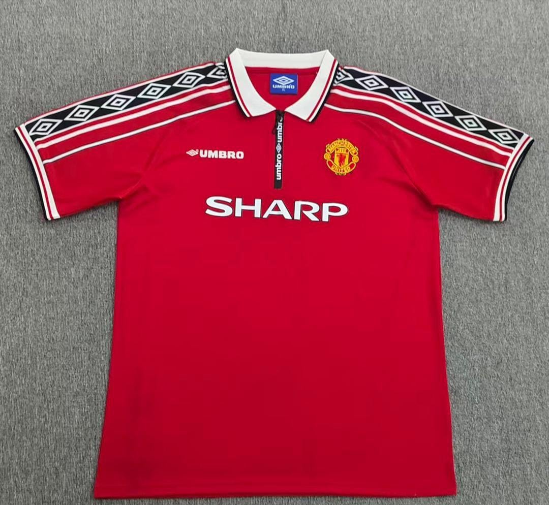 Red Manchester United Umbro jersey with Sharp logo laid flat.