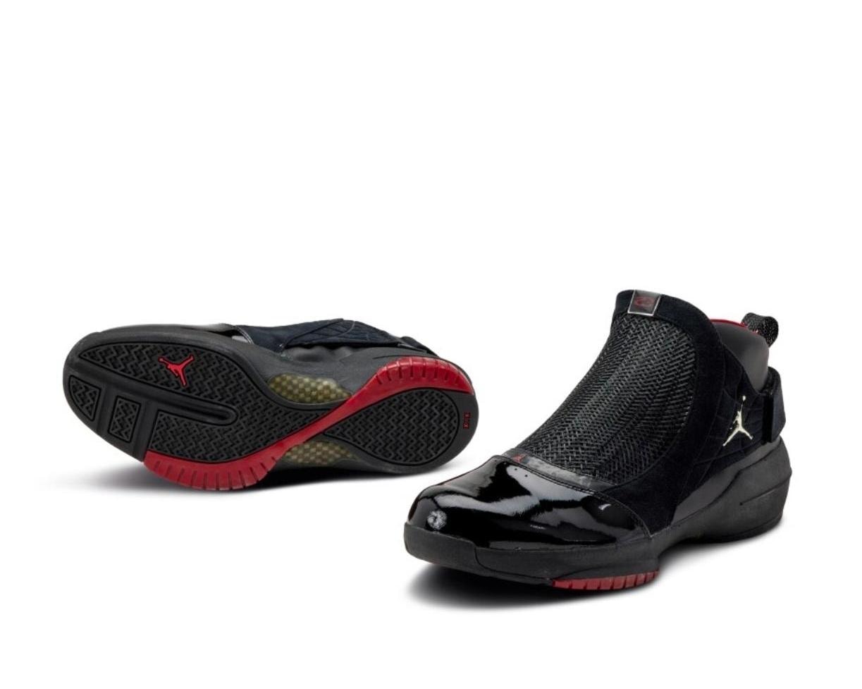 Black Air Jordan sneakers showing mesh, patent leather, red sole and Jumpman logo from multiple views.