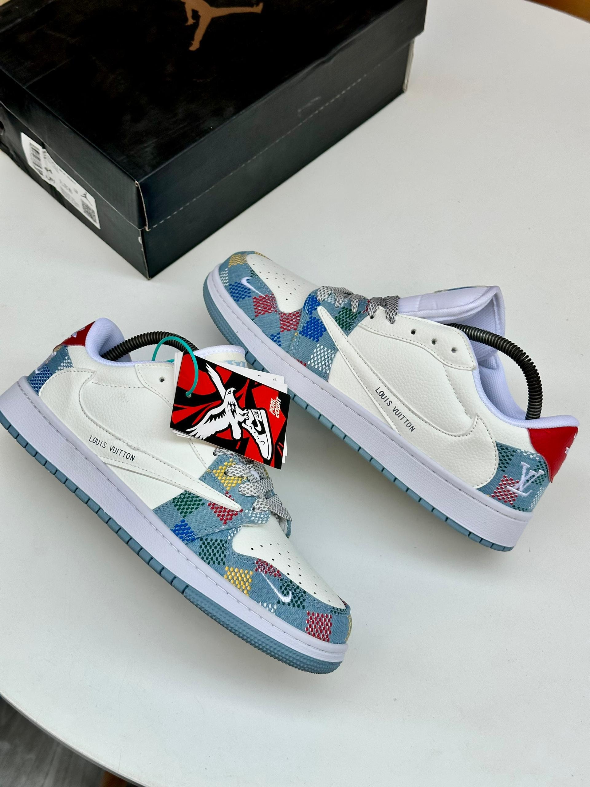 White Nike sneakers with multicolored LV pattern patches and red accents.