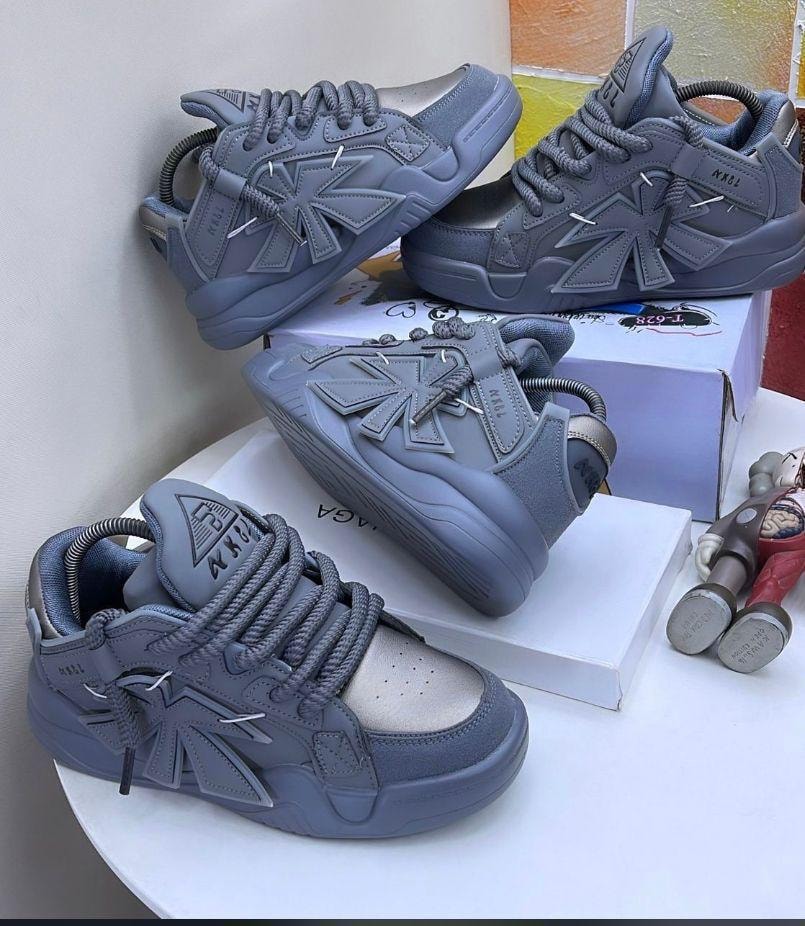 Gray chunky sneakers with large cross emblem and thick laces, shown from multiple angles.