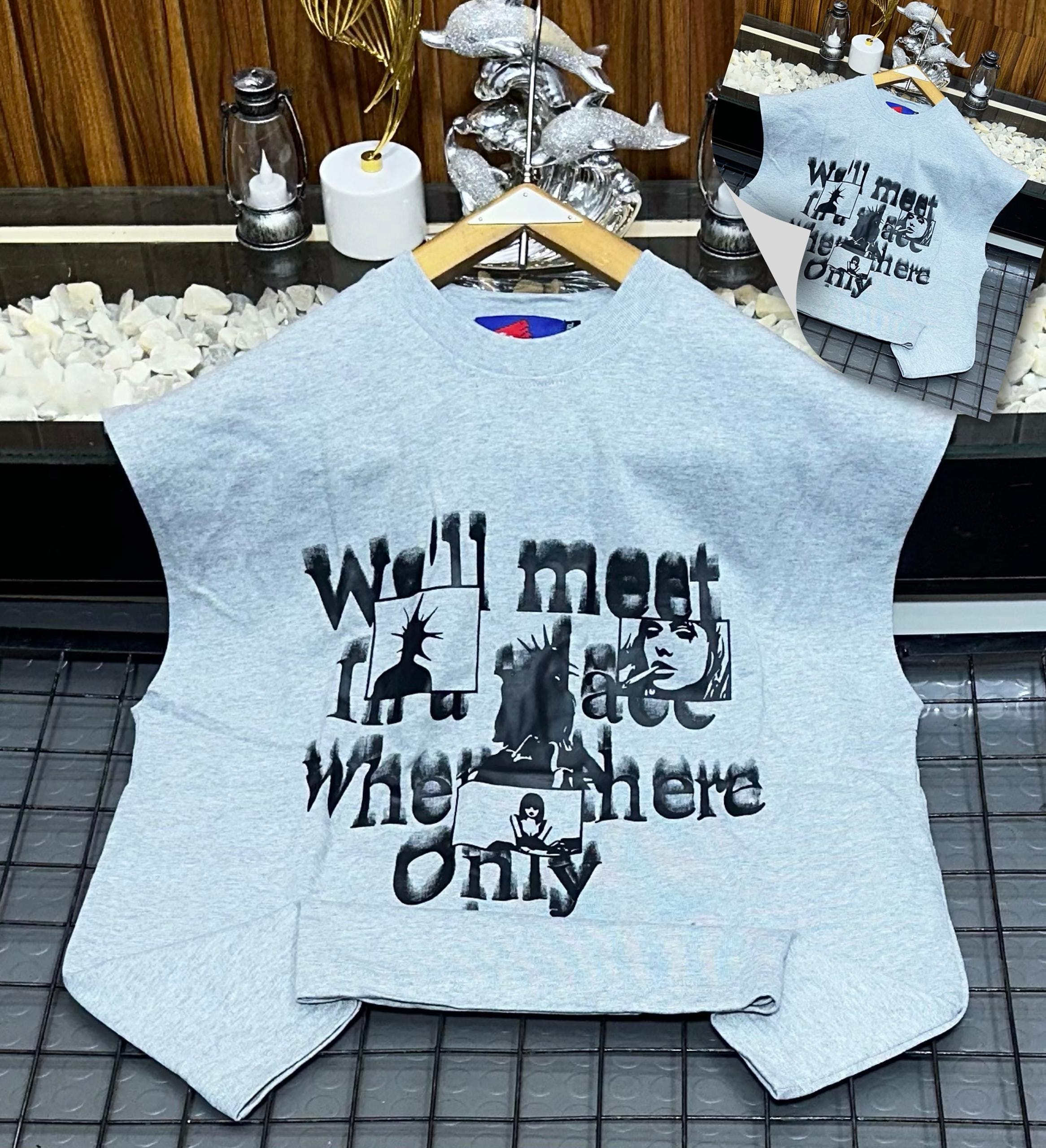 Gray armless graphic t-shirt laid flat showing front print.