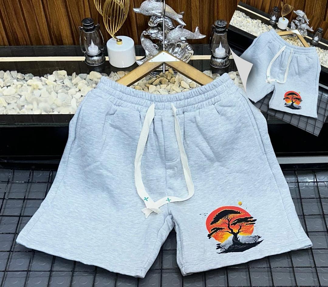 Light gray unisex shorts with sunset tree graphic print.