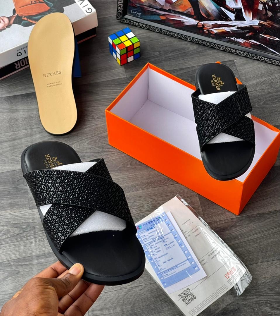 Black crisscross strap slide with textured pattern and HERMES insole.
