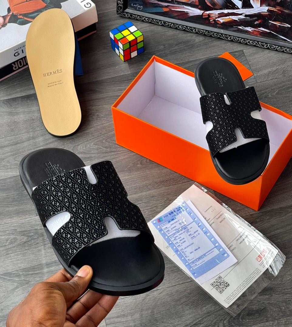 Black textured slide with H-shaped cutout and geometric pattern, shown with insole.