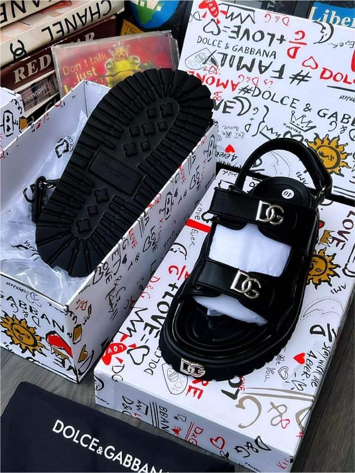 Black Dolce & Gabbana platform sandal displayed in logo-covered box.