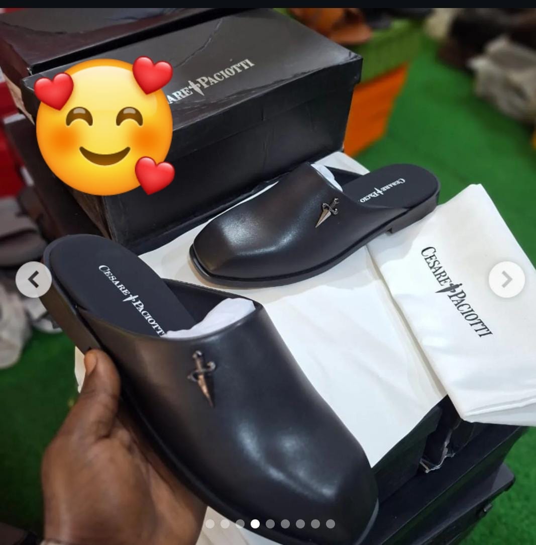 Black Cesare Paciotti mule with dagger logo, shown with box, dust bag and hand-held view.