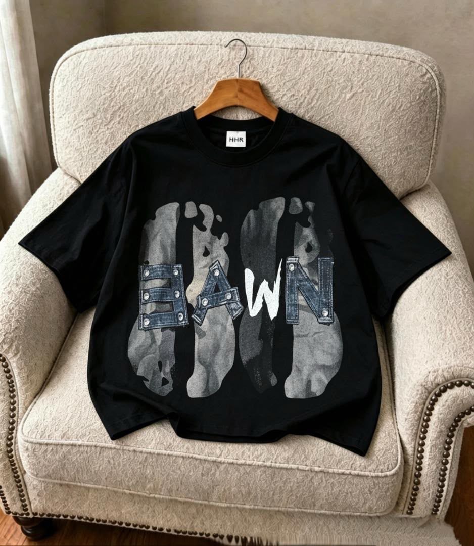 Black Dawn graphic t-shirt with stylized lettering, displayed on chair.