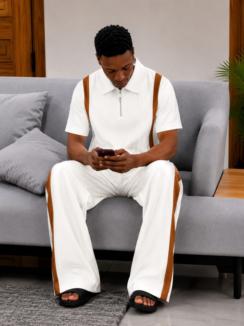 Man wearing white ribbed 2-piece set with brown contrast stripes.