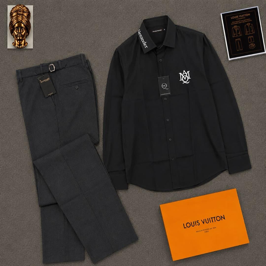 Black long sleeve McQueen logo shirt paired with gray trousers and orange box.