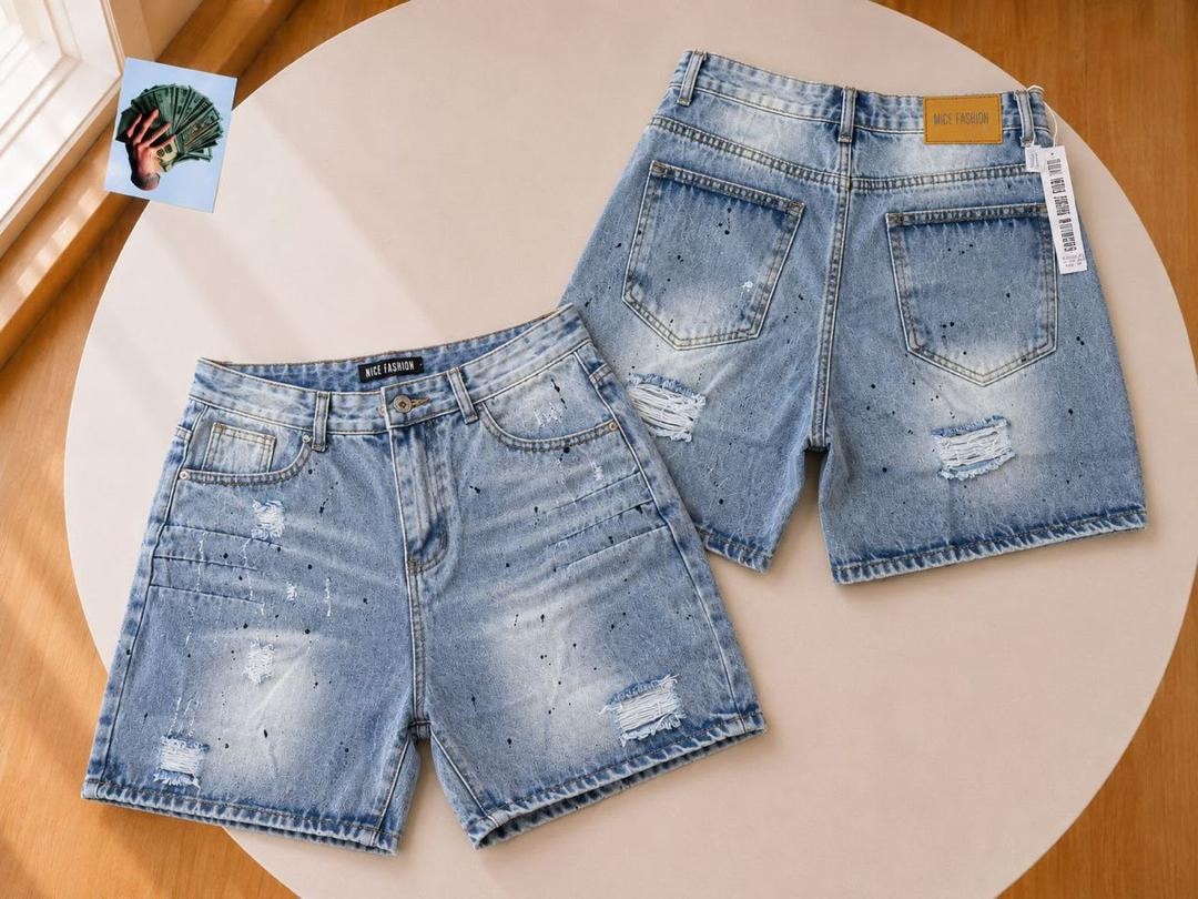Front and back of light blue denim shorts with black splatter distressing and rips.