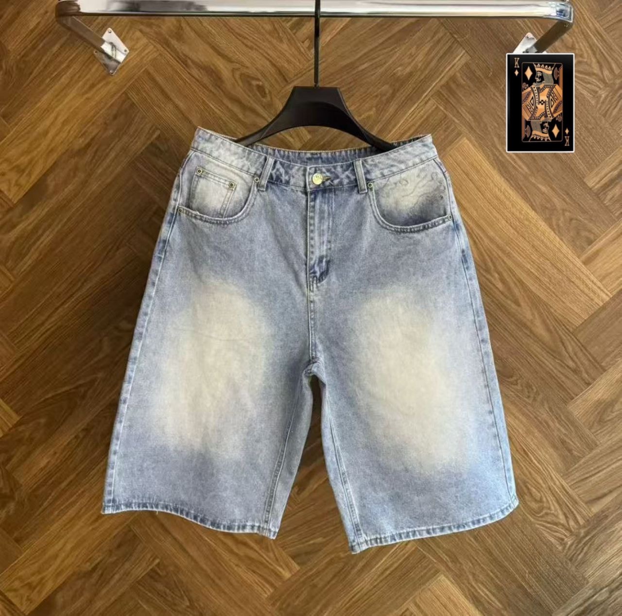 Front view of faded light wash denim jorts with button closure and front pockets.