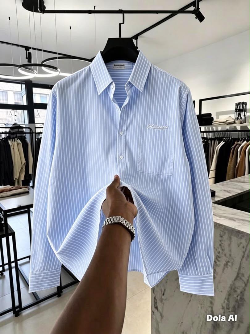 Front view of light blue and white striped button-down shirt with Relaxed chest embroidery held in store.