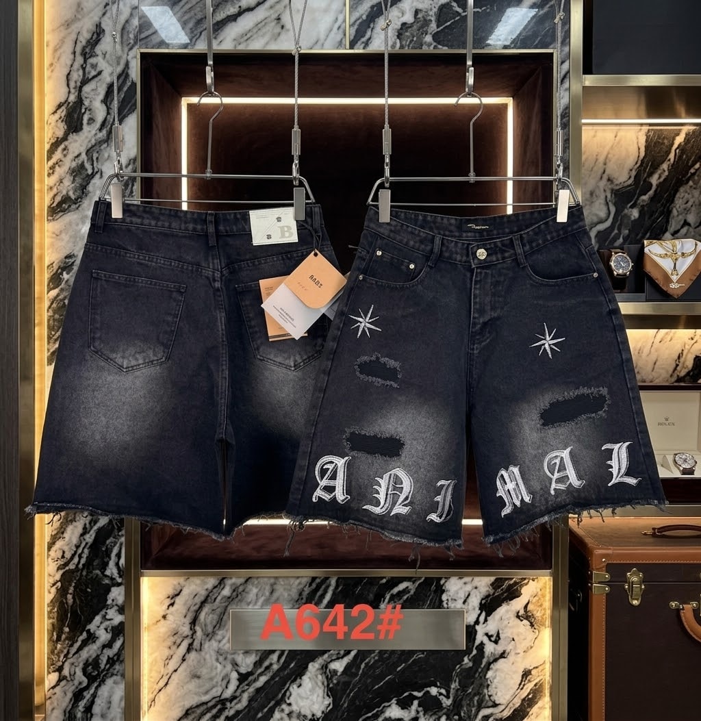 Dark denim shorts with ANIMAL text embroidery, stars, and distressed rips shown in retail display.