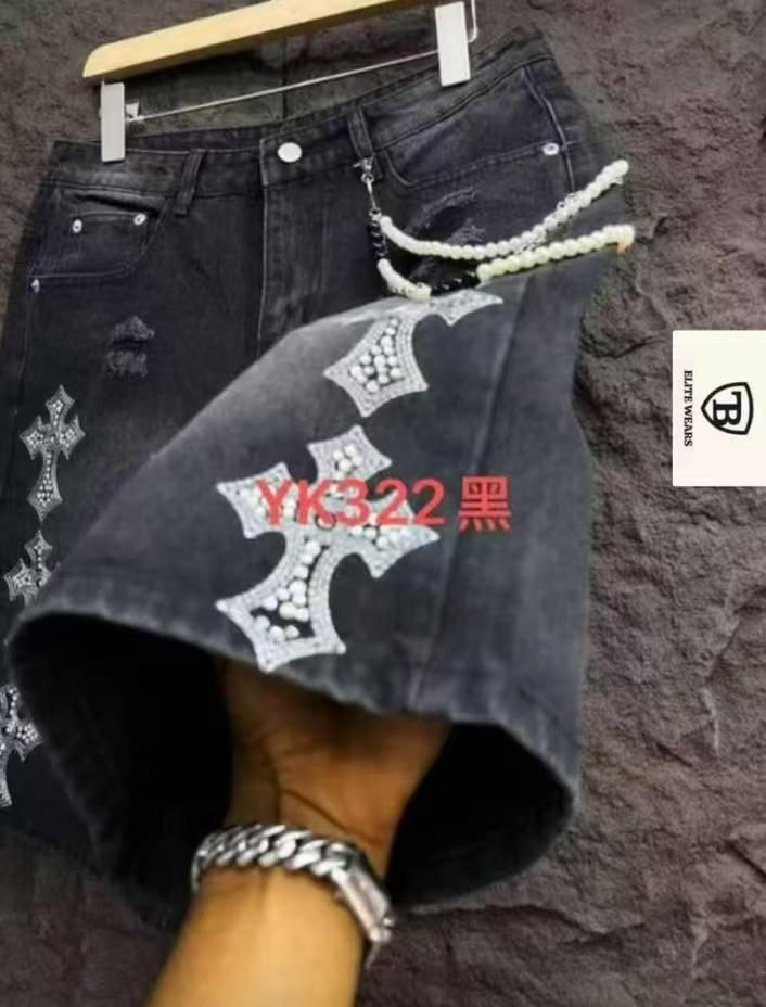 Black denim shorts with large rhinestone cross designs and chain accessory.