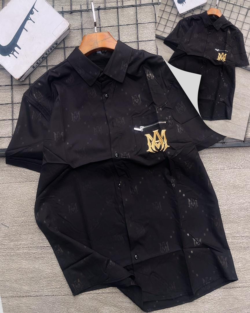 Black short sleeve AMIRI monogram pattern shirt with gold logo.