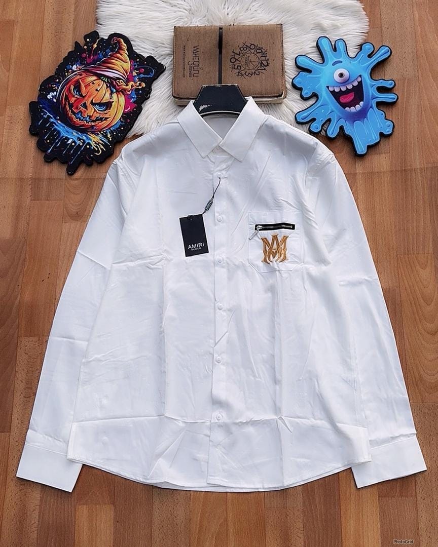 White long sleeve AMIRI logo pocket shirt on wooden floor.