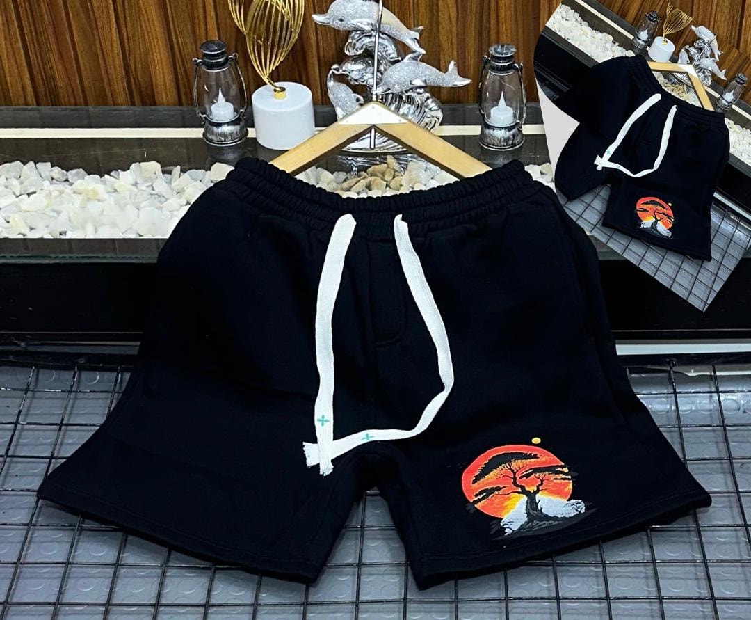 Black fleece shorts with embroidered sunset tree design on the leg.