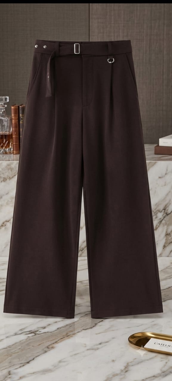 Dark brown high-waisted flare trousers shown full length on marble floor.