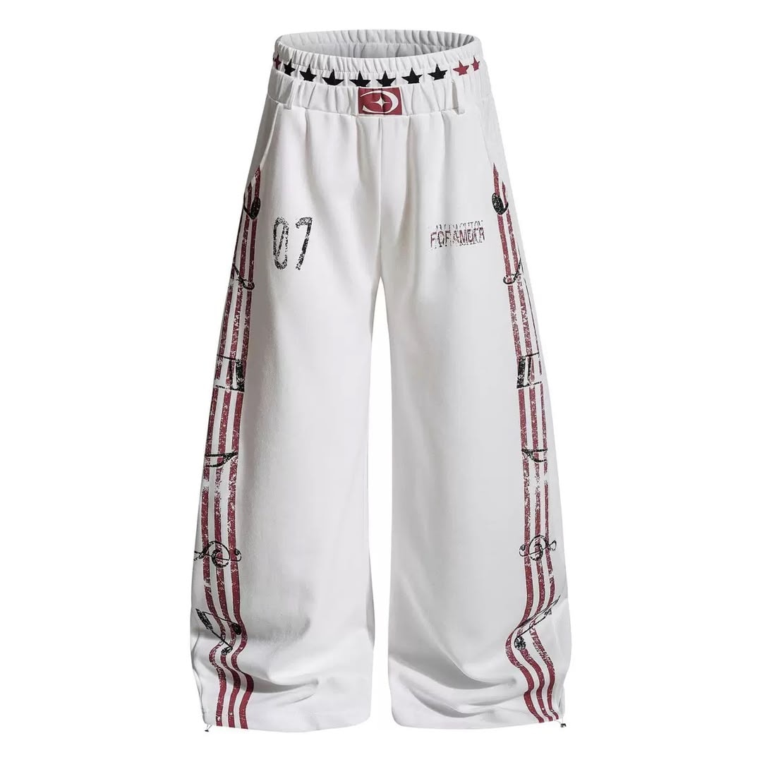 Close-up front view of white graphic wide-leg joggers with side prints.