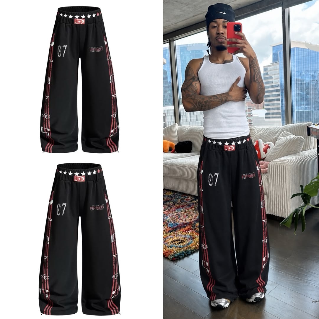 Black graphic joggers shown in flat lays and worn by model with tattoos.