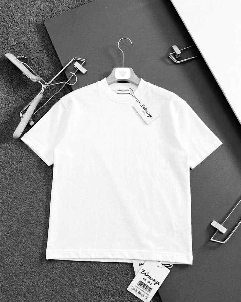White plain polo shirt displayed on hanger with visible Balenciaga tags and branding.