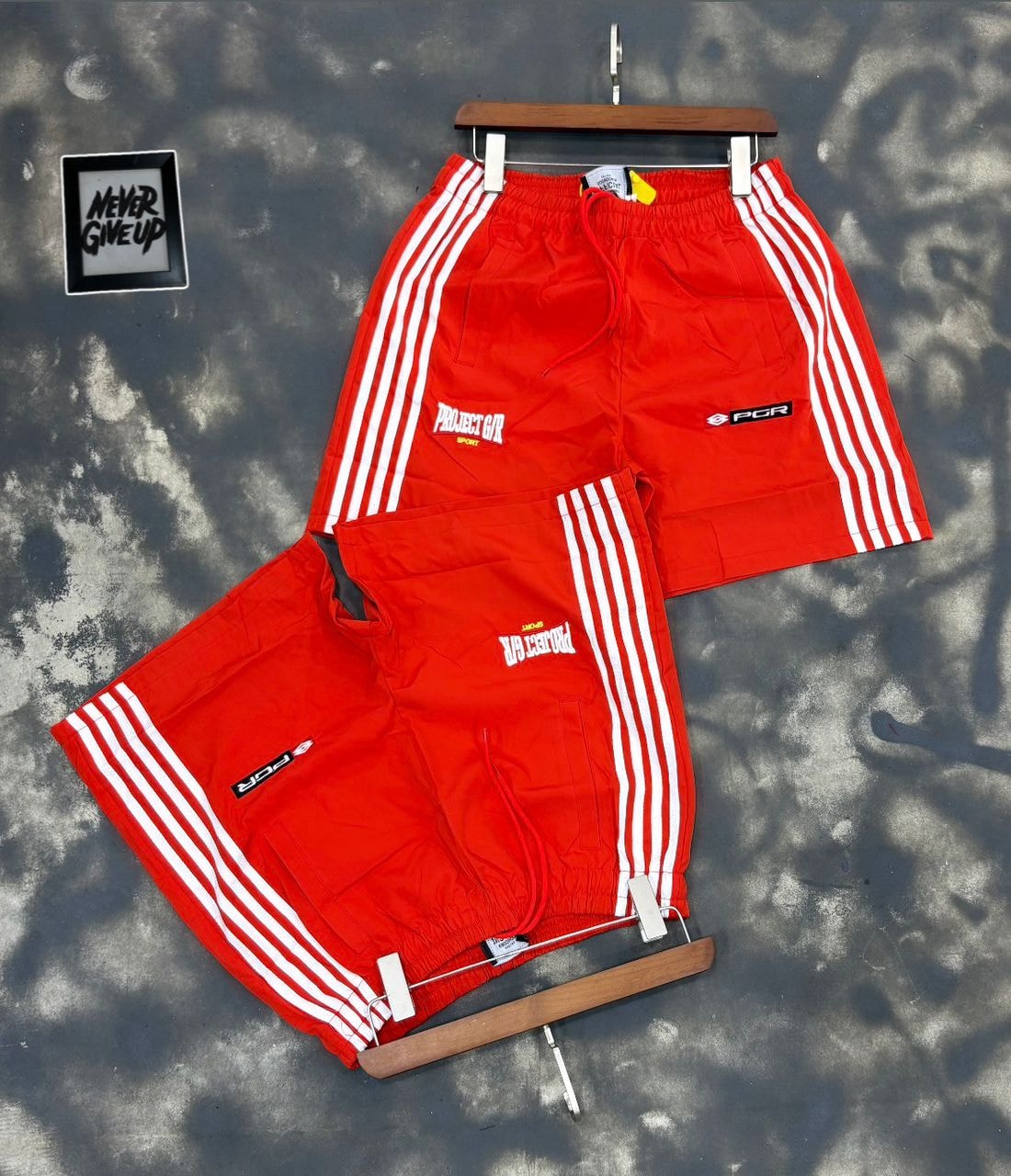 Red Projector Sport striped shorts on hanger and flat lay.